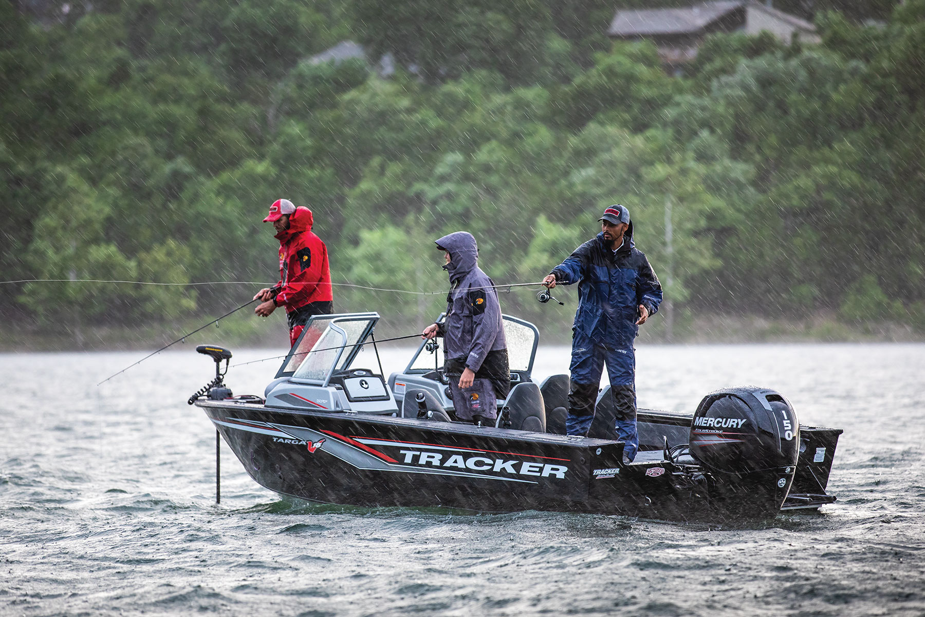 Three men fishing in the rain on Tracker Boat
